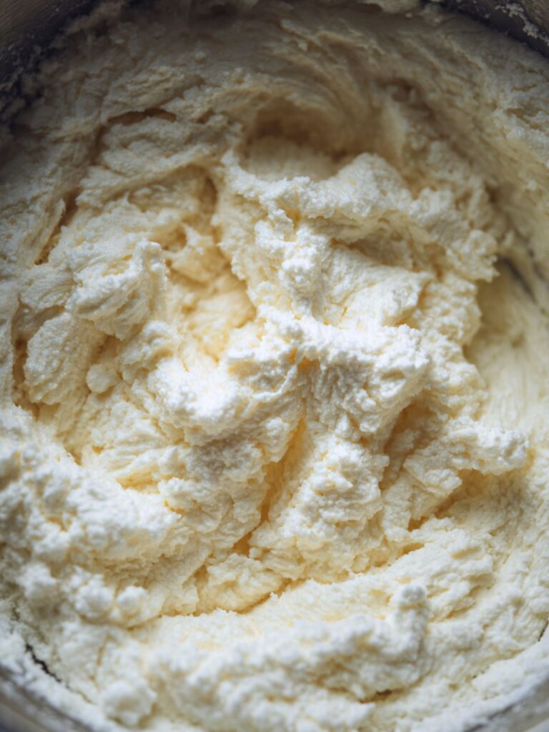 pale fluffy butter and sugar creamed mixture in stand mixer bowl for strawberry crunch cupcake batter